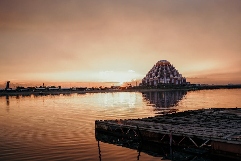 Capture of Makassar's Floating Mosque at sunset reflecting over calm waters.